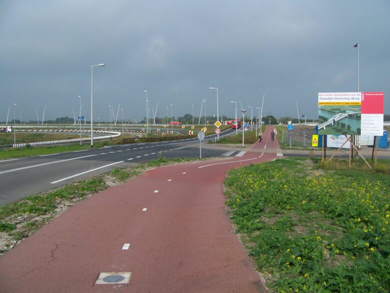 Cyklostezka podél dálnice A1 poblíž Amsterdamu a odbočka do sídliště IJburg