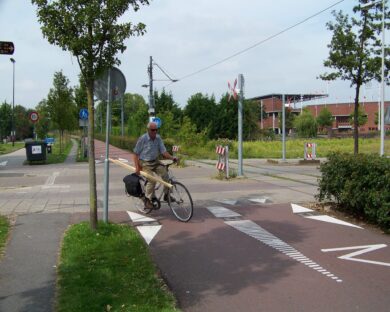 Cyklisté na křižovatce Piet Kranenbergpad a ulice IJsbaanpad v Amsterdamu